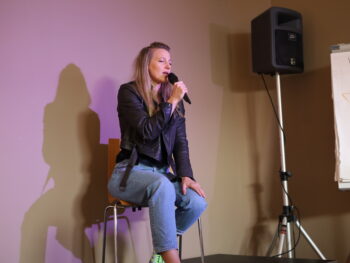 starke Sängerin performt mit starker Stimme lässig auf einem Hocker